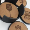 Wein-Korkuntersetzer mit Motiven „Wine not?“ und „It’s wine o’clock“ neben dem Halter