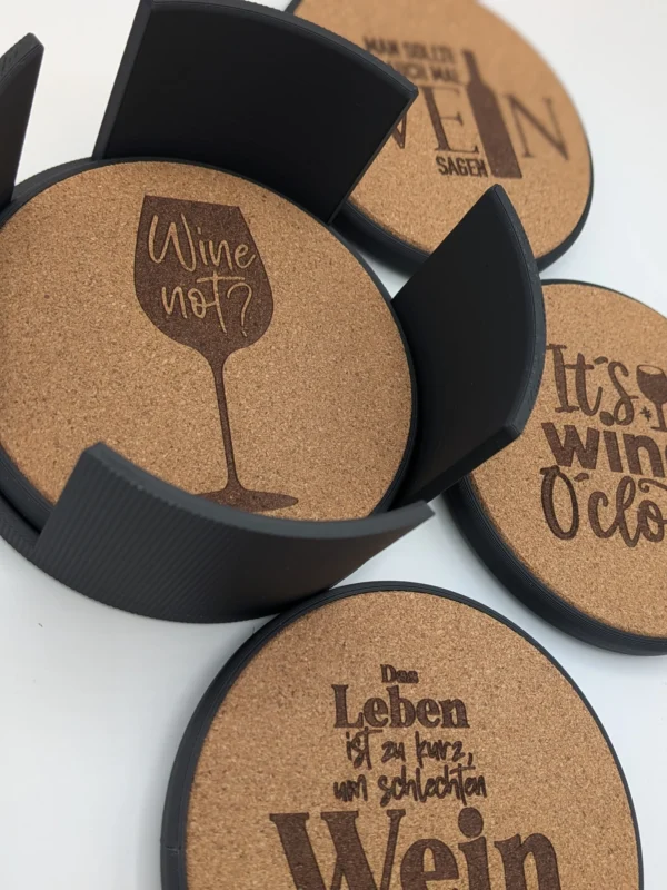 Wein-Korkuntersetzer mit Motiven „Wine not?“ und „It’s wine o’clock“ neben dem Halter